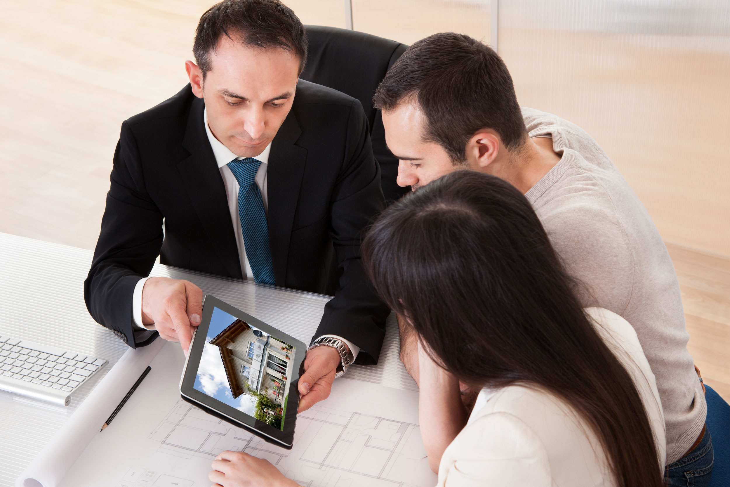 Realtor looking at homes with homebuyers on a tablet